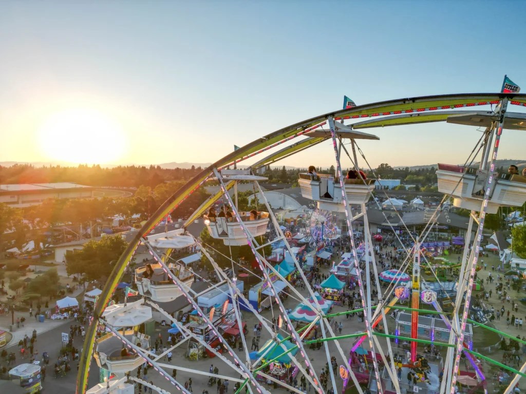 Large Ferris wheel with sun in distance