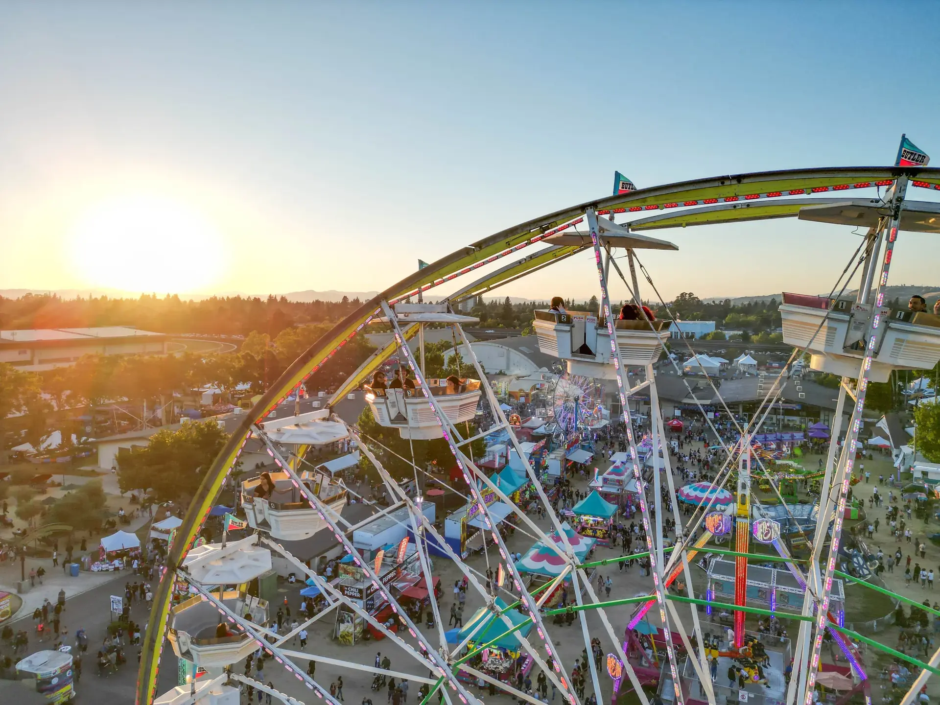 Large Ferris wheel with sun in distance